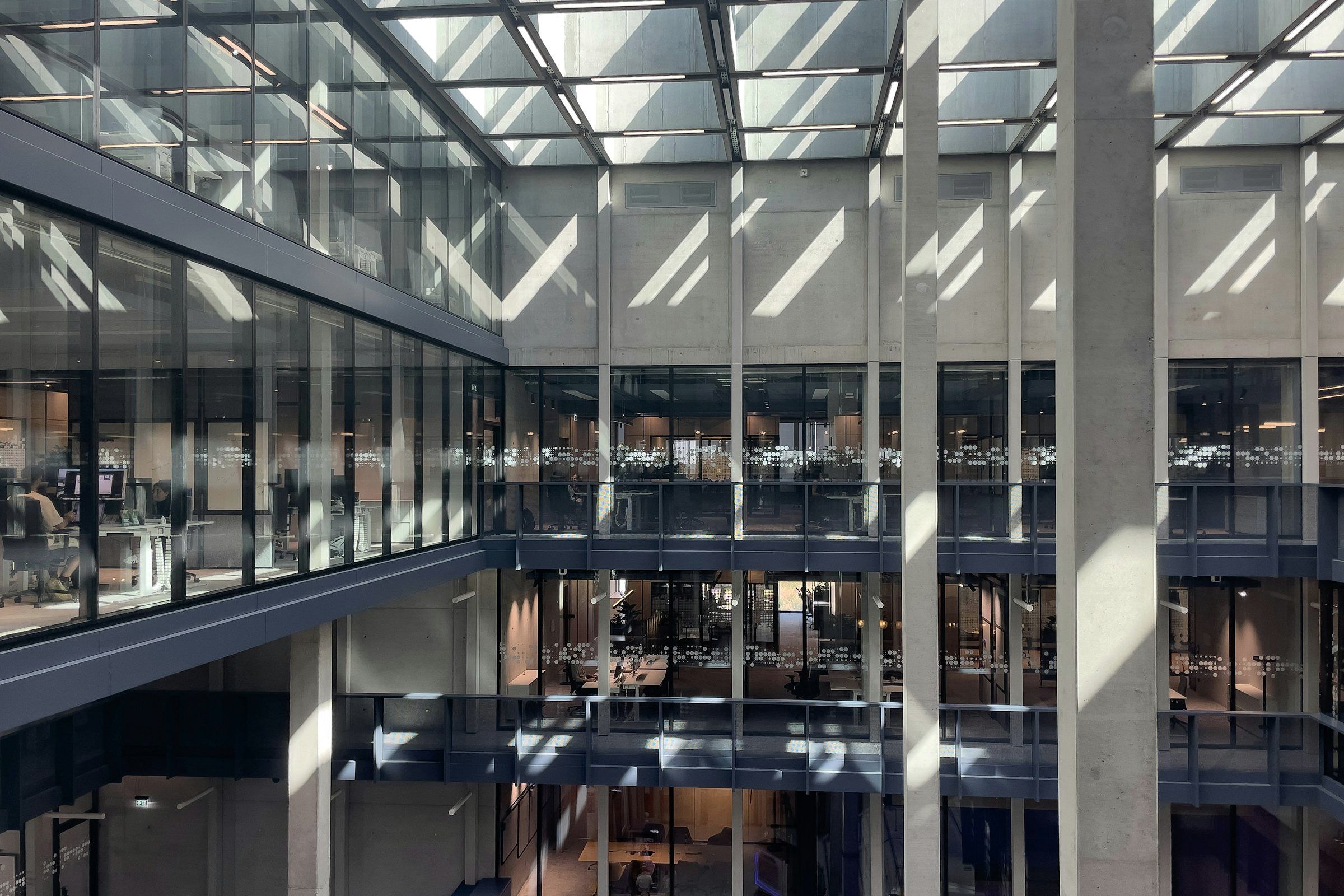 Atrium eines Bürogebäudes mit Glasfassaden über mehrere Etagen